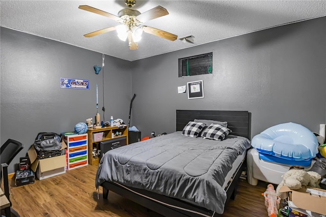 bedroom featuring a textured ceiling, ceiling fan, and hardwood / wood-style flooring