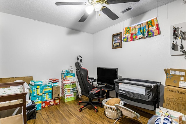 office area with a textured ceiling, ceiling fan, and wood-type flooring