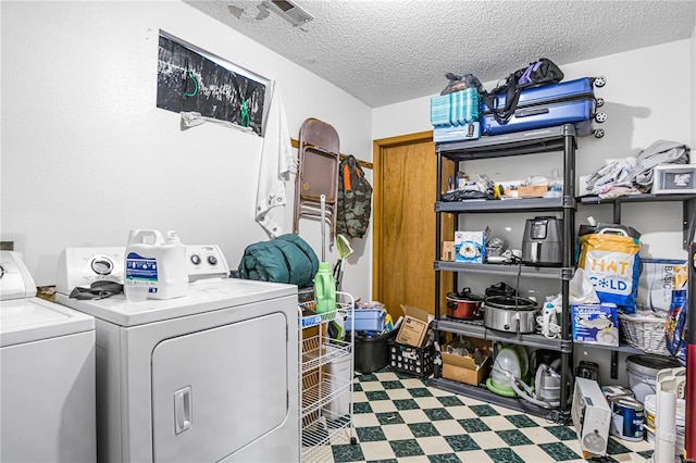 laundry room with a textured ceiling and washer and dryer