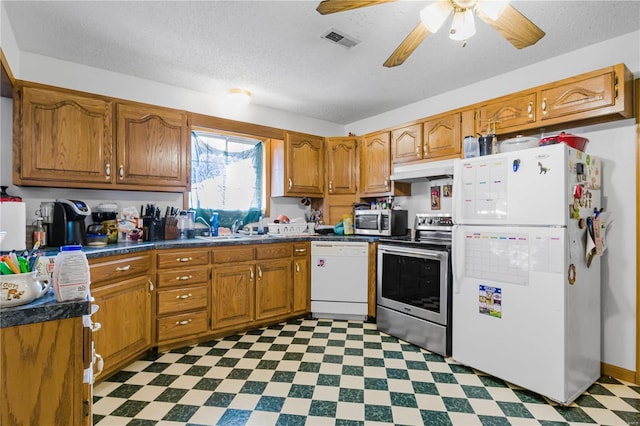 kitchen with a textured ceiling, ceiling fan, appliances with stainless steel finishes, and sink