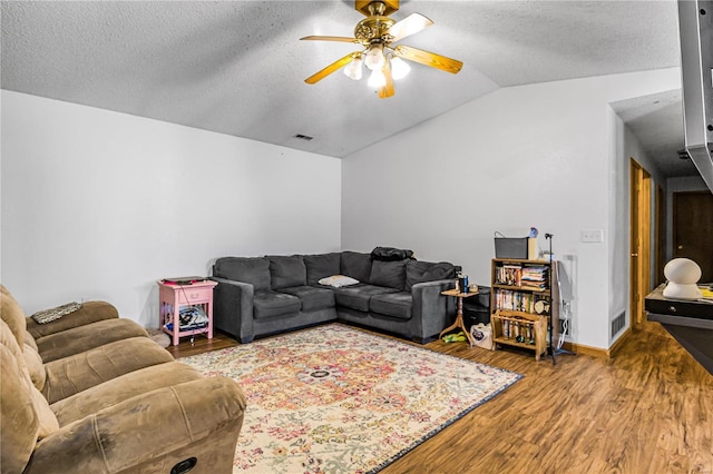 living room featuring vaulted ceiling, ceiling fan, a textured ceiling, and hardwood / wood-style floors