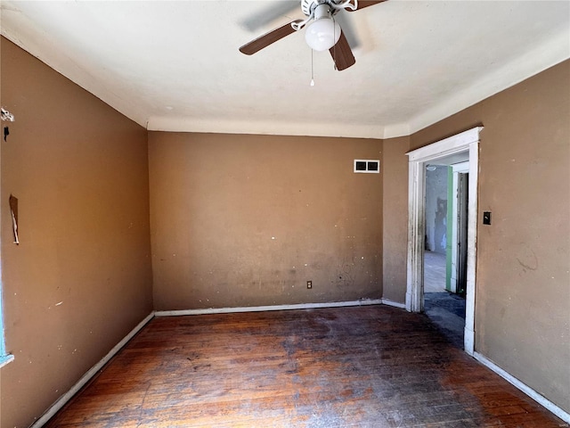 empty room with ceiling fan and dark hardwood / wood-style flooring