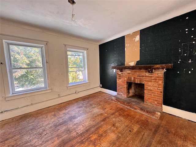 unfurnished living room featuring a fireplace, dark hardwood / wood-style flooring, and a healthy amount of sunlight