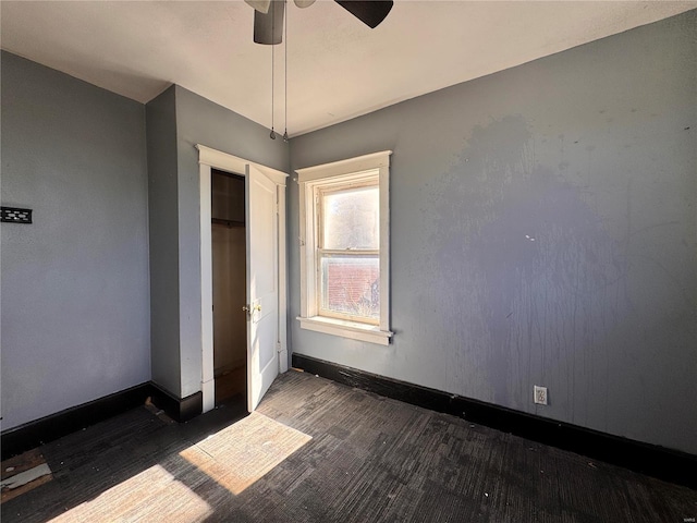 unfurnished bedroom with dark hardwood / wood-style flooring, ceiling fan, and a closet