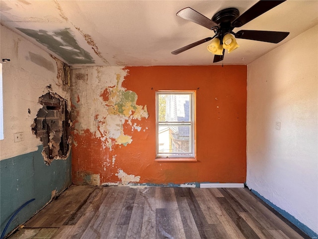 empty room with ceiling fan and dark wood-type flooring