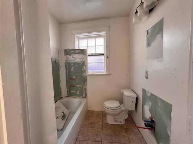 bathroom featuring toilet, a bath, and tile patterned floors