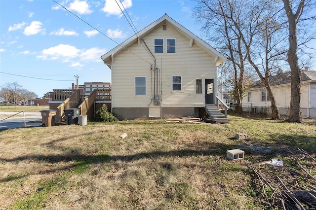 rear view of house with a deck and a lawn