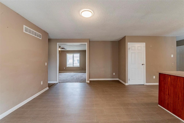 empty room with a textured ceiling and ceiling fan