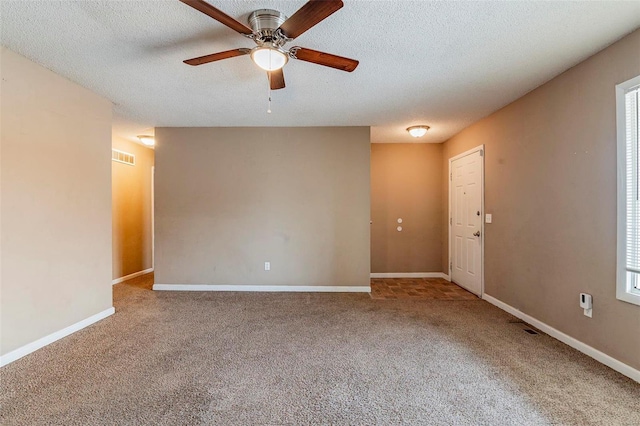 unfurnished room with ceiling fan, carpet floors, and a textured ceiling