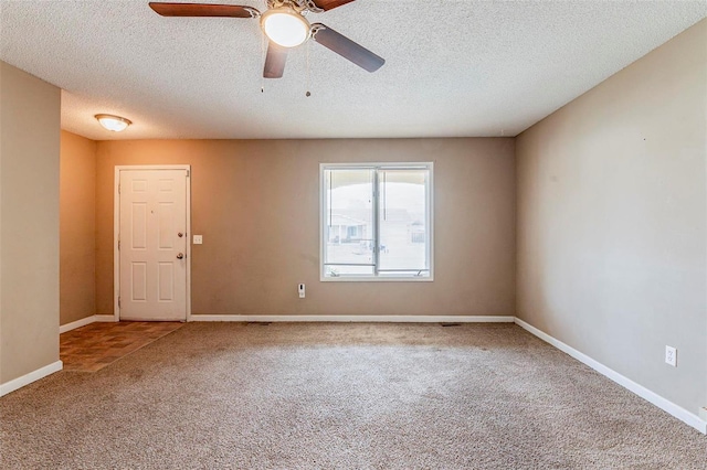 carpeted spare room featuring a textured ceiling and ceiling fan