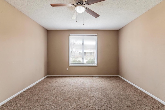 carpeted spare room featuring ceiling fan and a textured ceiling