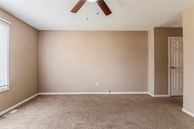 carpeted empty room featuring a textured ceiling and ceiling fan