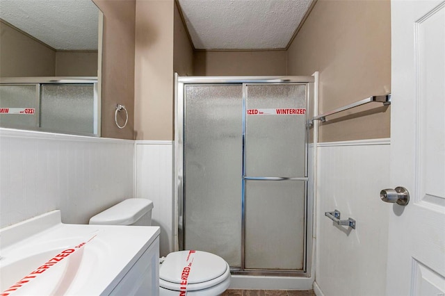 bathroom with walk in shower, vanity, a textured ceiling, and toilet