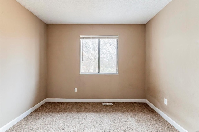 carpeted spare room with a textured ceiling