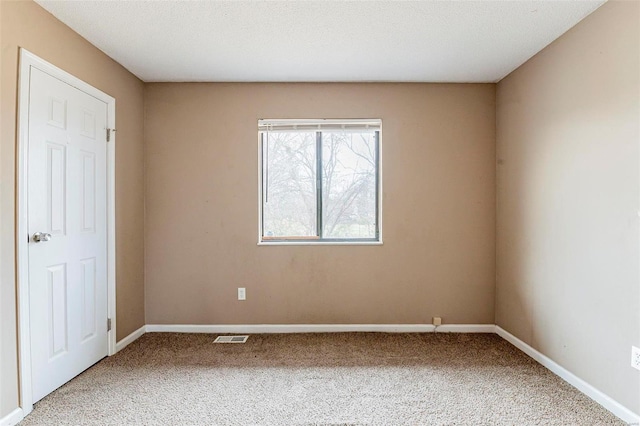 carpeted spare room featuring a textured ceiling