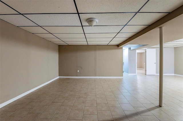 basement featuring a drop ceiling and light tile patterned floors