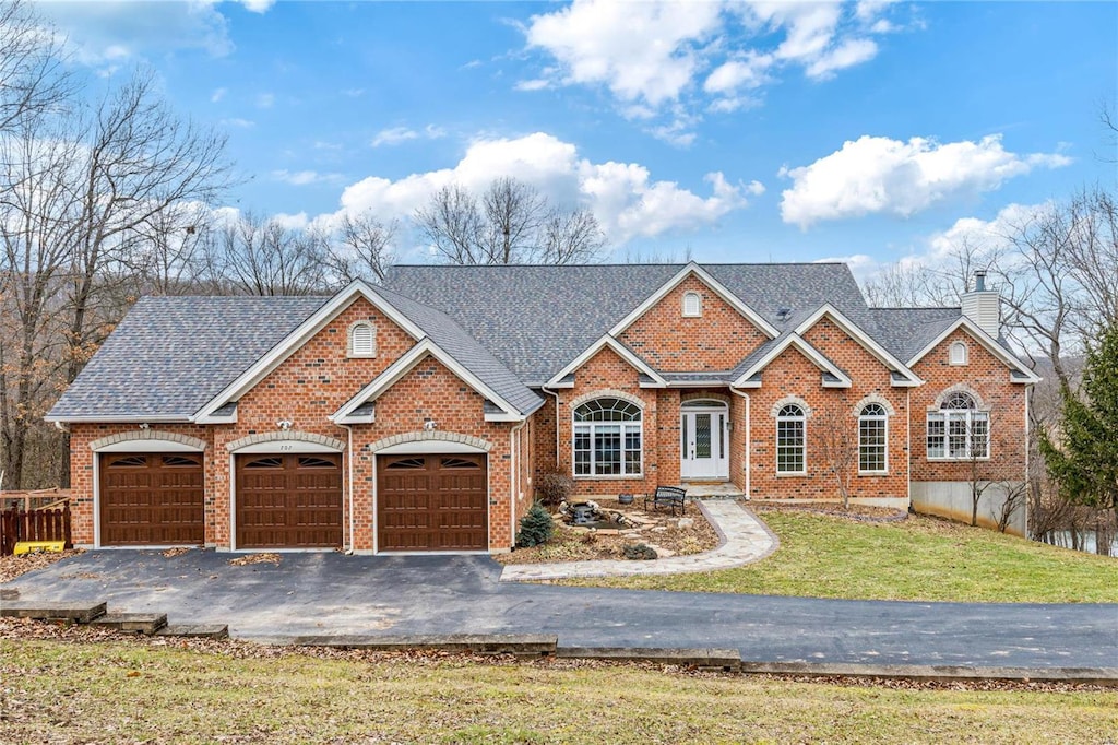 view of front of home with a garage and a front lawn