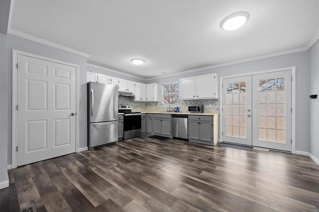 kitchen with dark hardwood / wood-style flooring, french doors, white cabinets, and appliances with stainless steel finishes