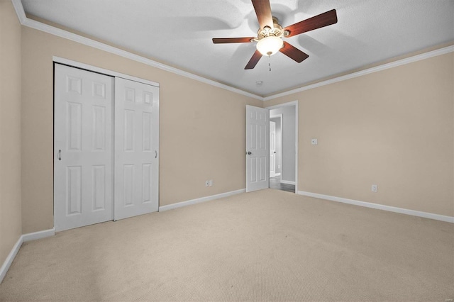 unfurnished bedroom with ceiling fan, a textured ceiling, light carpet, a closet, and ornamental molding