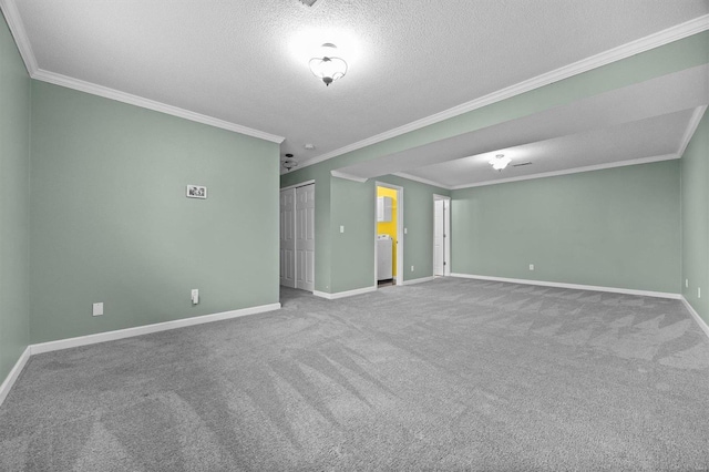 empty room featuring carpet, crown molding, a textured ceiling, and washer / dryer