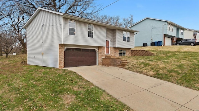 split foyer home with a front yard and a garage