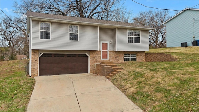 bi-level home featuring a garage and a front lawn