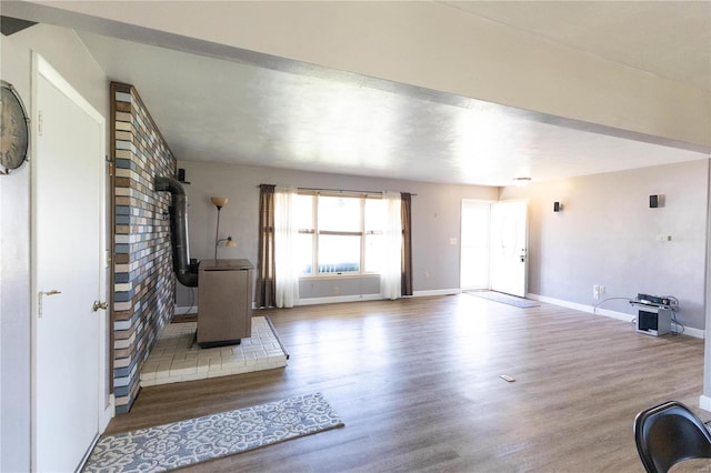 unfurnished living room featuring wood-type flooring and a wood stove