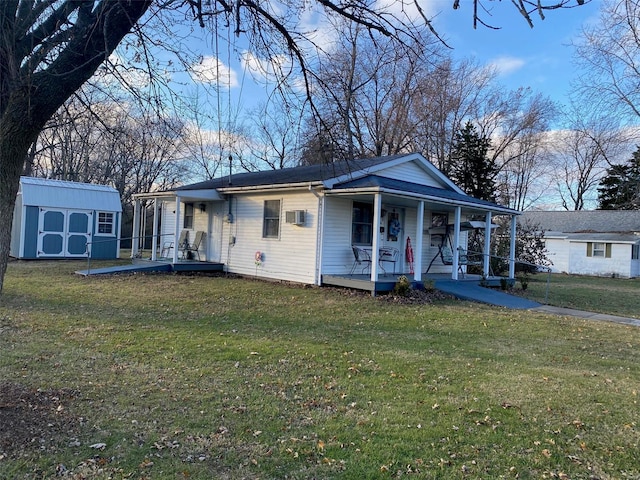 view of front of house featuring covered porch, a wall unit AC, a storage unit, and a front yard