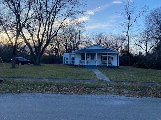 view of front of home with a porch and a lawn