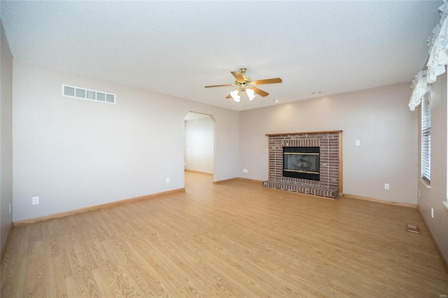 unfurnished living room with a fireplace, light hardwood / wood-style flooring, and ceiling fan