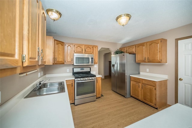 kitchen featuring appliances with stainless steel finishes, light wood-type flooring, and sink