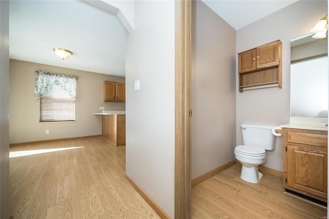 bathroom with hardwood / wood-style flooring, vanity, and toilet