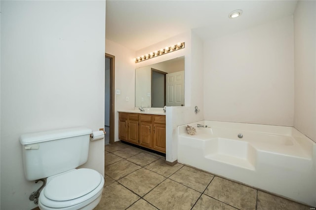 bathroom featuring tile patterned floors, vanity, a bath, and toilet