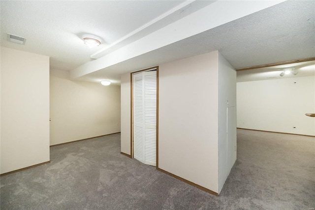 basement with carpet and a textured ceiling