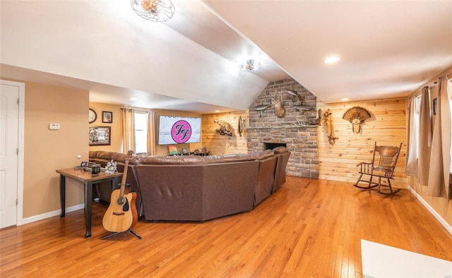 living room featuring wood walls, wood-type flooring, and lofted ceiling