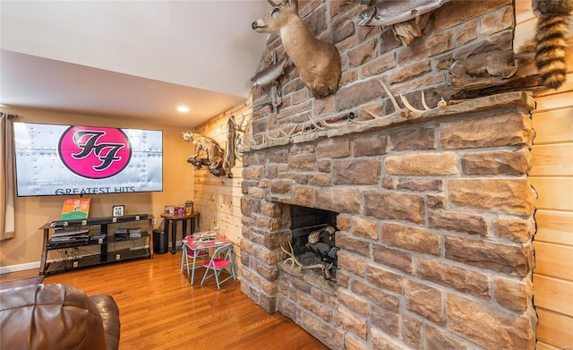 living room featuring hardwood / wood-style flooring and a stone fireplace