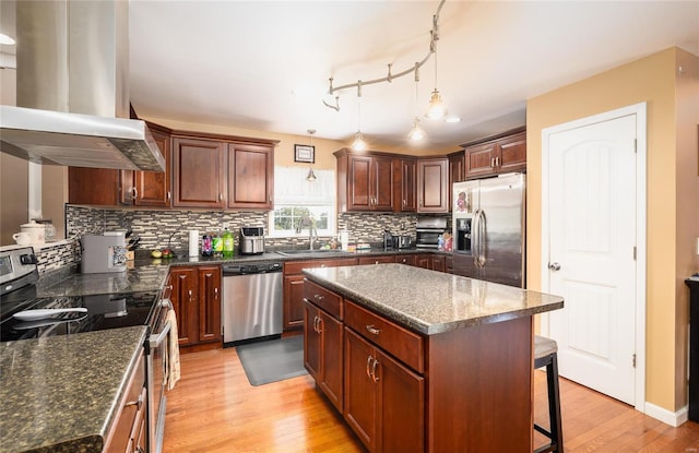 kitchen featuring sink, stainless steel appliances, light hardwood / wood-style floors, island range hood, and a kitchen island