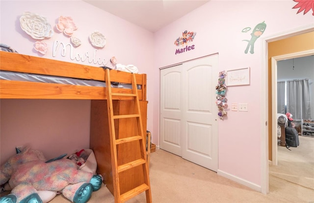 bedroom featuring light colored carpet and a closet