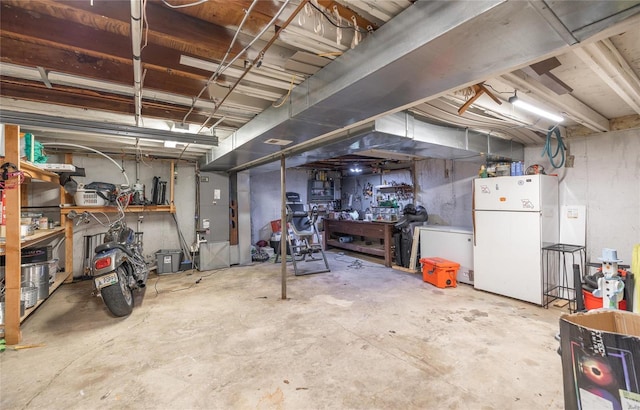 basement with white refrigerator and a workshop area