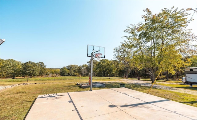 view of basketball court with a yard