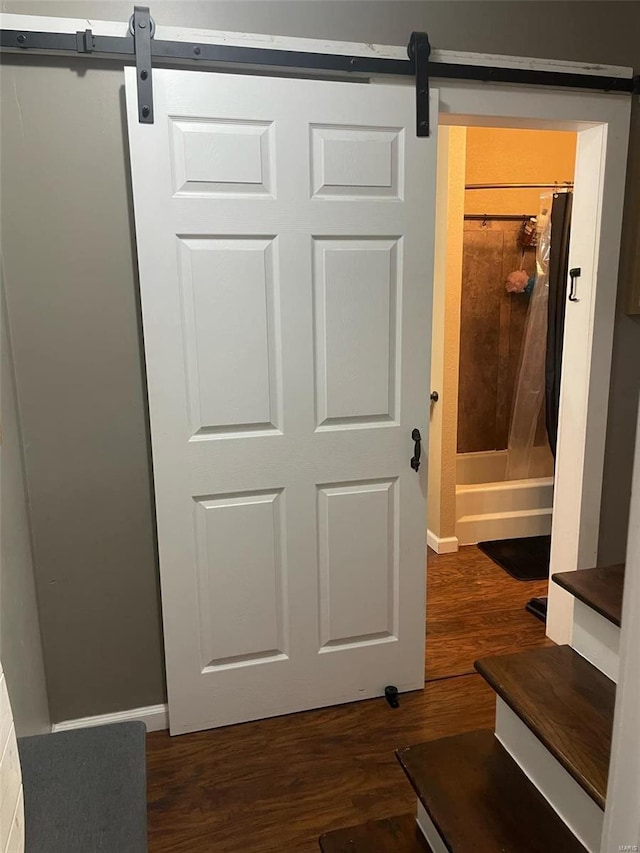 interior details with a barn door and wood-type flooring