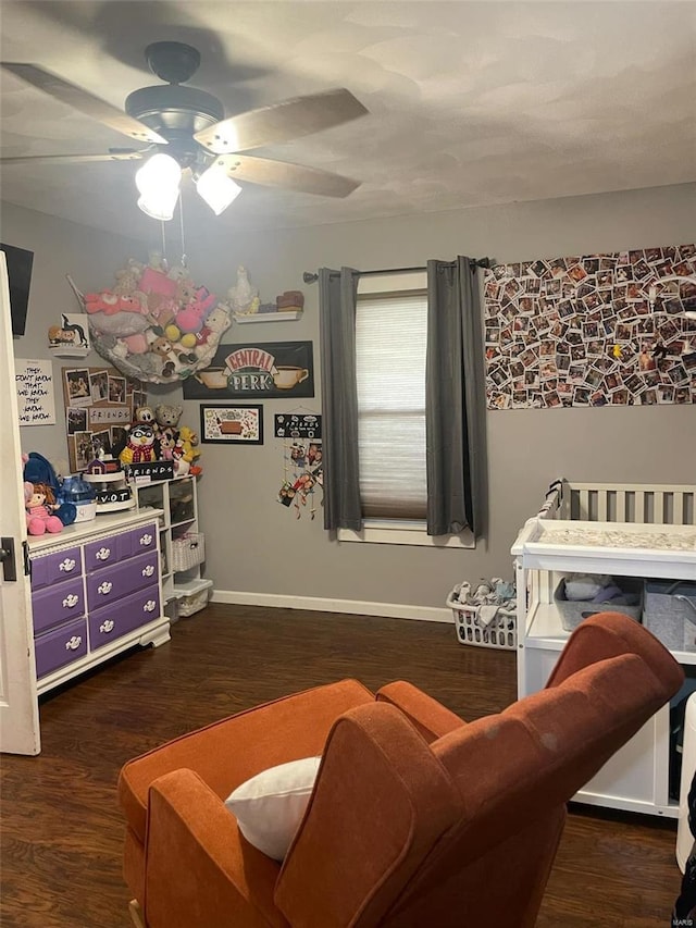 bedroom featuring a crib, dark hardwood / wood-style floors, and ceiling fan