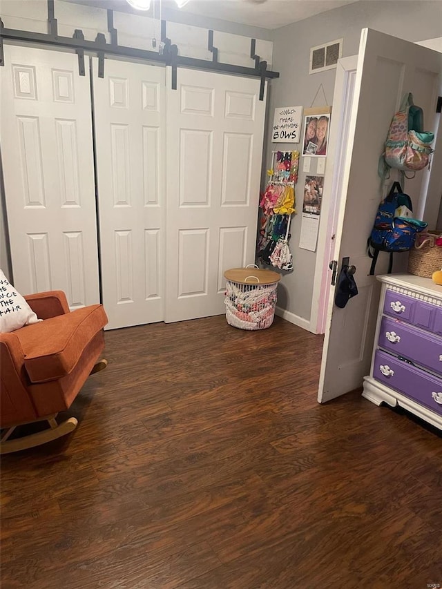 living area featuring dark hardwood / wood-style floors and a barn door