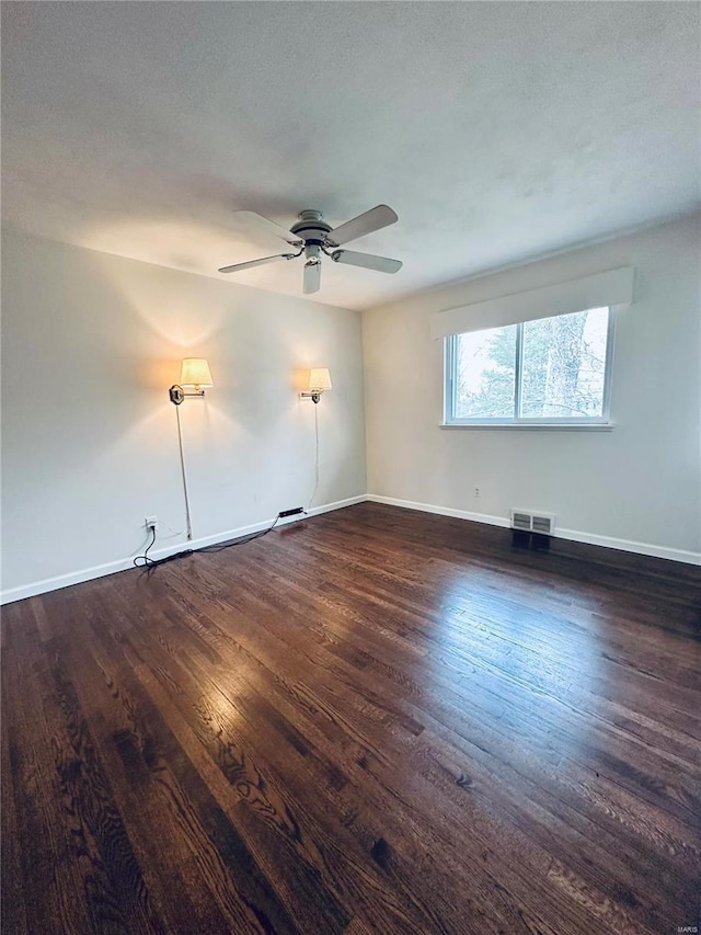 empty room featuring a textured ceiling, ceiling fan, and dark wood-type flooring