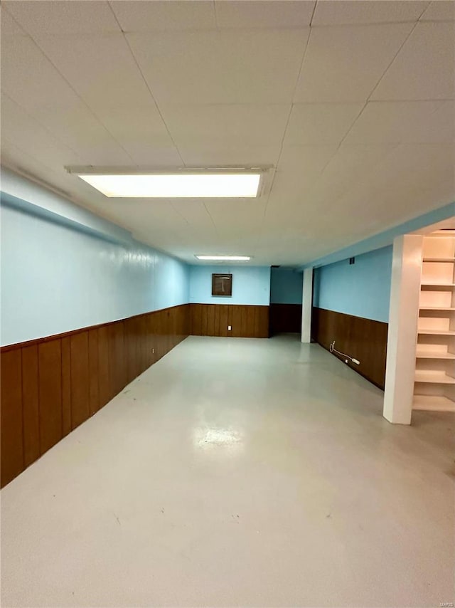 basement featuring wood walls