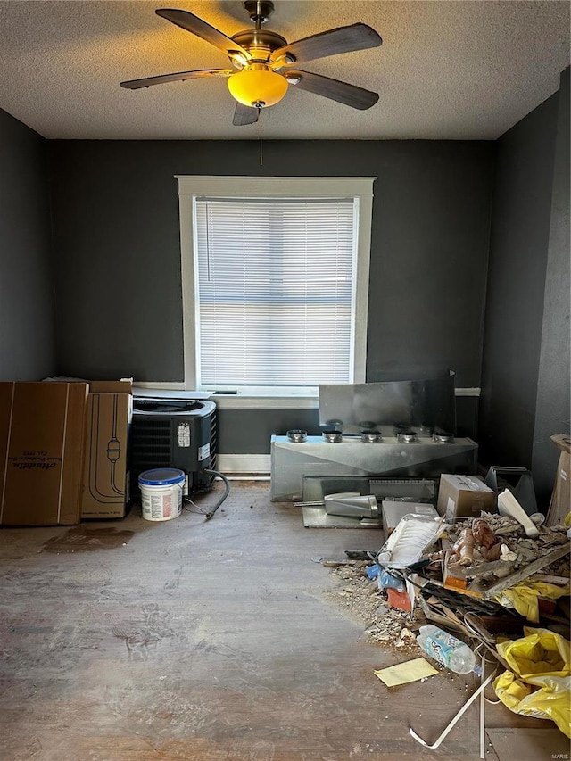 miscellaneous room with a textured ceiling, concrete floors, and ceiling fan