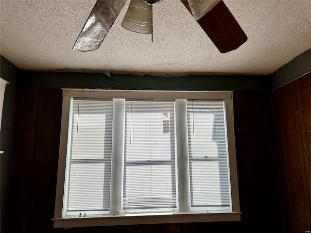 interior details with ceiling fan and a textured ceiling