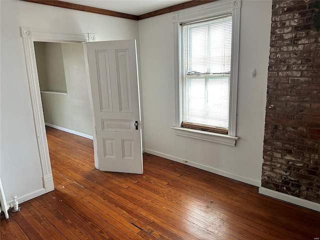 spare room featuring dark hardwood / wood-style flooring and crown molding