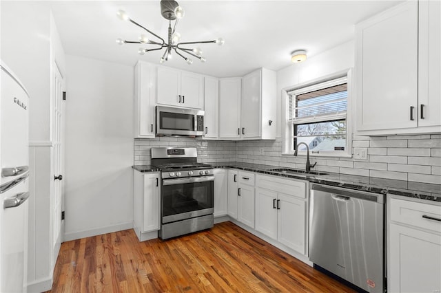 kitchen featuring sink, white cabinets, stainless steel appliances, and dark hardwood / wood-style floors