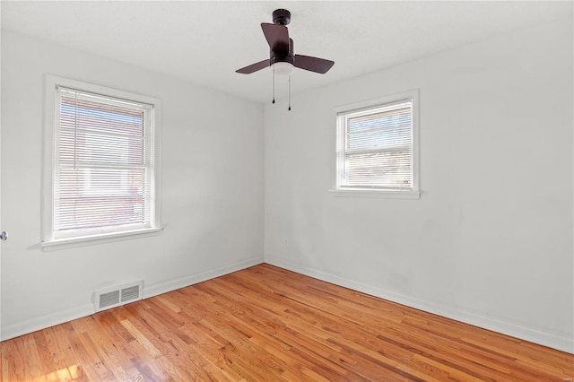 spare room featuring light hardwood / wood-style floors, a wealth of natural light, and ceiling fan